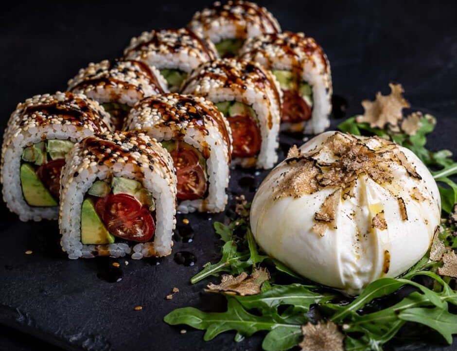 Rolls à l'avocat et à la tomate cerise nappés de balsamique, servis avec une burrata à la truffe sur un lit de roquette