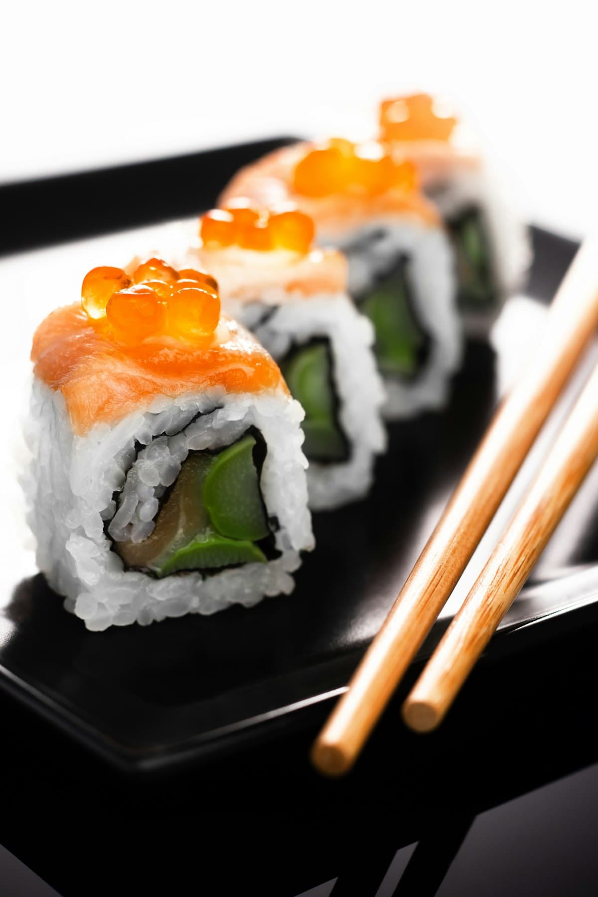 Rolls garnis d'œufs de saumon sur ardoise noire