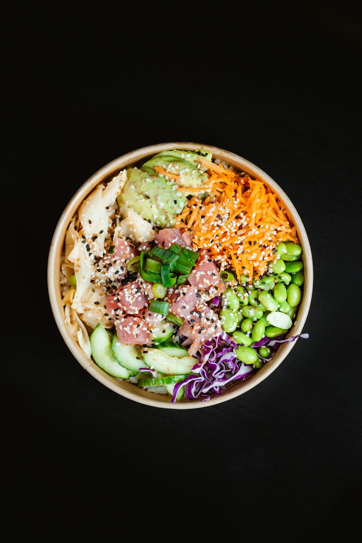 Poke bowl coloré vu du dessus sur fond sombre