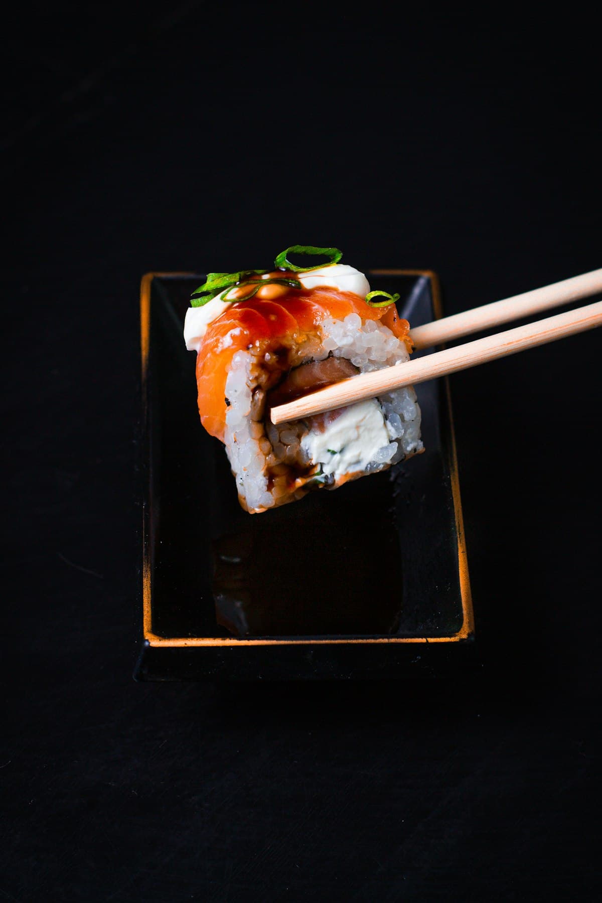 California roll saisi aux baguettes sur fond noir