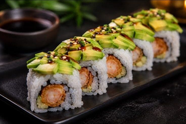 Dragon rolls à la crevette tempura recouverts de lamelles d'avocat et de sauce teriyaki
